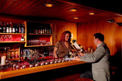 a man and a woman standing behind a bar at Hotel Beausite in Interlaken