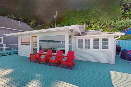 a group of red chairs sitting on a deck at Sunrise Beach House in Gig Harbor