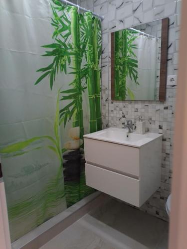 a bathroom with a sink and a plant on the shower curtain at Apartament IRI Băile Herculane in Băile Herculane