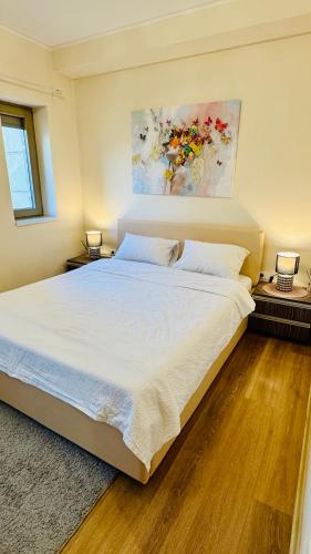 a bedroom with a large white bed and two lamps at SHoliday Parter Clădire Nouă Spațiu Modern & Parcare Privată in Dumbrăviţa