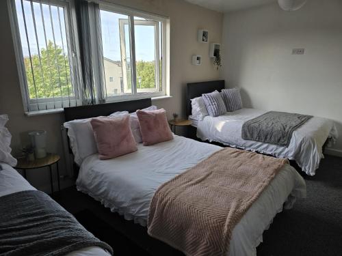 a bedroom with two beds with pillows and a window at Room 5 Shared House in L7 in Liverpool