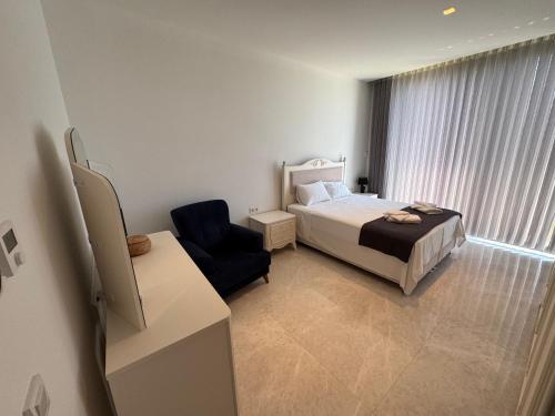 a hotel room with a bed and a chair at Villa Lodos in Bodrum City