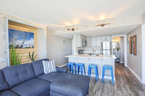 a living room with a blue couch and a kitchen at Unique Oceanfront Luxury Suite, Dogs Welcome! 406 in Myrtle Beach
