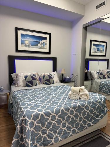 a bedroom with a large bed with a blue comforter at Downtown Toronto Condo with CN Tower View in Toronto