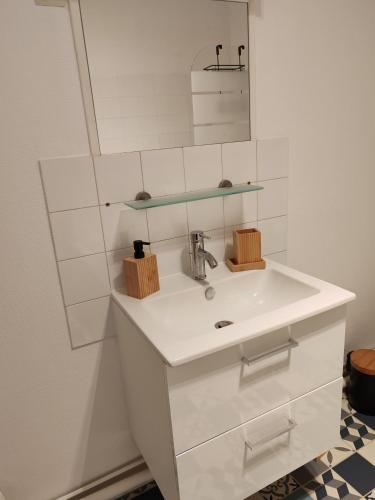 une salle de bain blanche avec un lavabo et un miroir dans l'établissement L'Escali'Bulle - Entre Gare et Centre-ville, à La Celle-sous-Gouzon