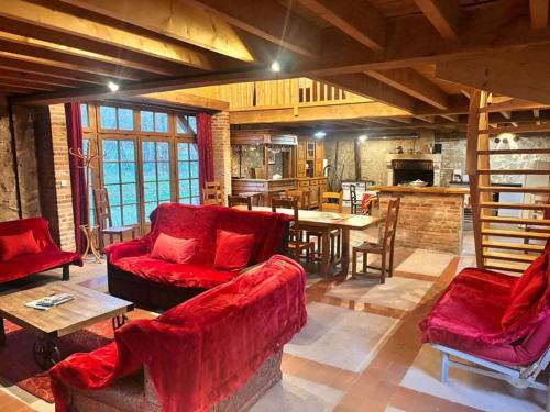 Il comprend un salon doté d'un mobilier rouge et une cuisine. dans l'établissement Maison du garde forestier, à Cour-Cheverny