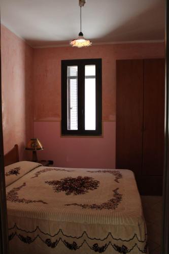 a bedroom with a bed and a window at Casa di Agata in Torrenova