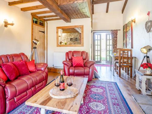 a living room with red leather furniture and a table at 1 bed property in Gower 77981 in Penclawdd