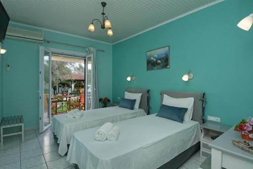 two beds in a room with blue walls at Kaspy Country Houses in Lygia