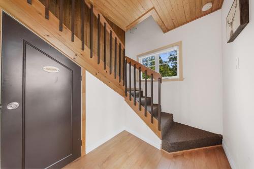 a hallway with a metal door and a staircase at Havre du Huit in Adstock