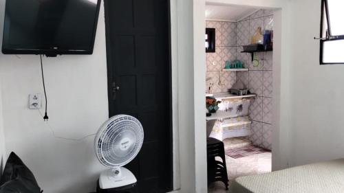 a room with a fan and a black door at Beira-Mar Guest House in Arraial do Cabo
