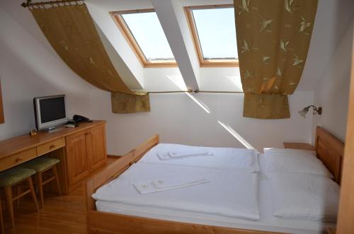 a bedroom with a bed and two windows at Penzión Salaš Cabaj in Nitra