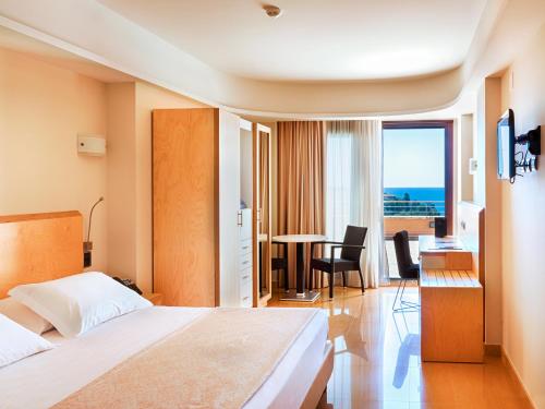 a hotel room with a bed and a table with a view at Taormina Panoramic Hotel in Taormina
