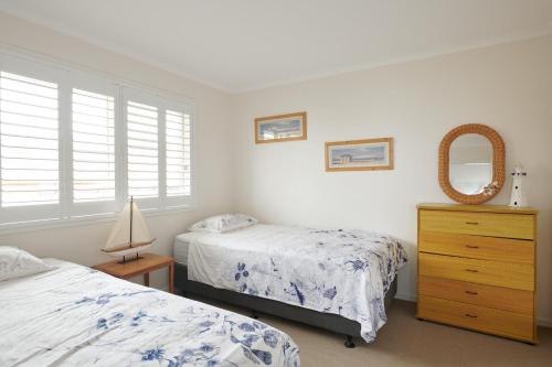 a bedroom with two beds and a dresser and a mirror at Castaway 2 in Harrington