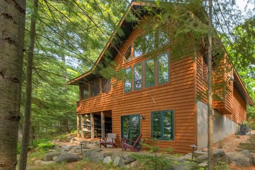 a log cabin in the woods with trees at The Cedar Lakehouse in Lake Tomahawk WI in Lake Tomahawk