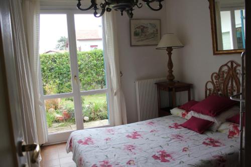 une chambre avec un lit et une grande fenêtre dans l'établissement Maison jardin plage Côte Basque, à Bidart