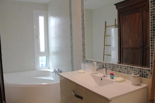 une salle de bain avec un lavabo, des toilettes et une baignoire dans l'établissement Maison jardin plage Côte Basque, à Bidart