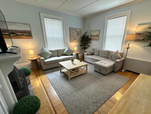 a living room with couches and a coffee table at Charming Victorian Home Downtown Newport in Newport