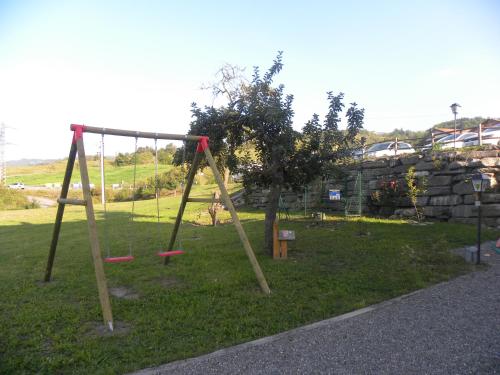 a park with a swing set in the grass at La Castagna Matta in Albareto