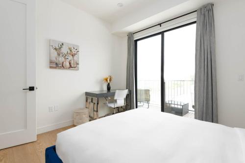 a bedroom with a white bed and a large window at Stylish Apartments in Glendale with Free Parking in Glendale