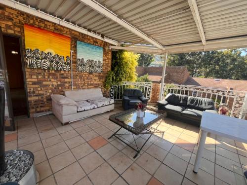 a patio with couches and a table on a patio at Tanya's home in Johannesburg