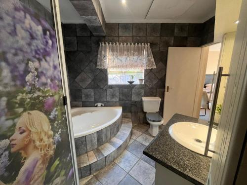 a bathroom with a tub and a sink and a toilet at Tanya's home in Johannesburg