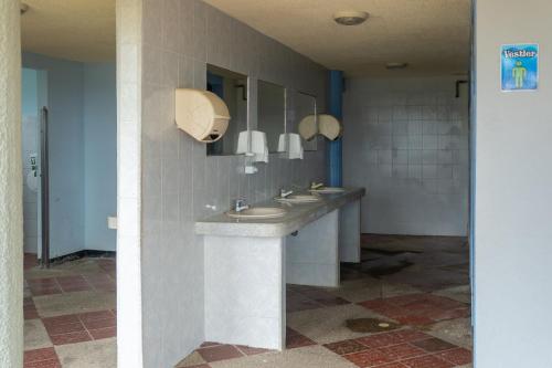 a bathroom with two sinks and two mirrors at Hotel Centro Recreacional Villa El Encanto in Belén