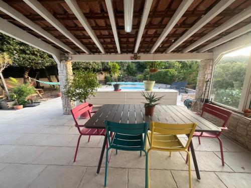 une table et des chaises en bois sur une terrasse dans l'établissement Belle villa proche du centre ville, à Saint-Maximin-la-Sainte-Baume