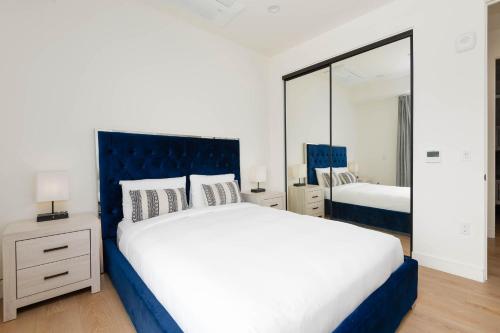a bedroom with a large white bed and a mirror at Stylish Apartments in Glendale with Free Parking in Glendale