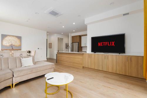 a living room with a couch and a tv on a wall at Stylish Apartments in Glendale with Free Parking in Glendale