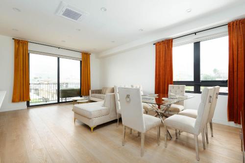 a dining room with a table and chairs and windows at Stylish Apartments in Glendale with Free Parking in Glendale