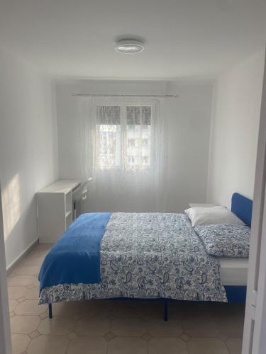 une chambre avec un lit bleu et une fenêtre dans l'établissement Sun appart, à Nice