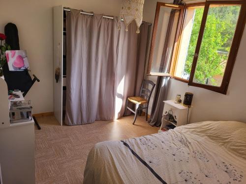 a bedroom with a bed and a window at Maison au cœur du Verdon 2 chambres et terrasse in Allemagne-en-Provence