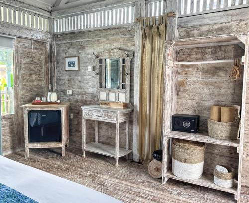 a room with a television and a table and a mirror at Kacchapa Resort and Restaurant in Sekongkang