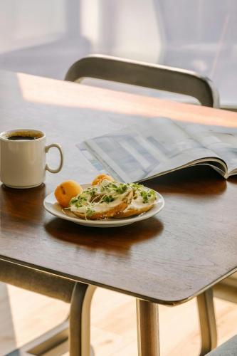 a plate of food on a table with a cup of coffee at Sonder by Marriott Bonvoy Maisonneuve Apartments Downtown in Montréal