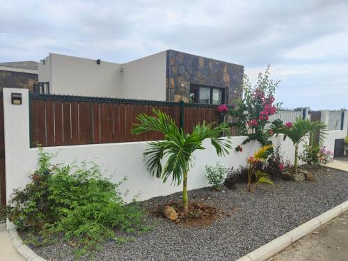 a white building with a fence and some plants at Villa Lune D'Eau in Poste Lafayette