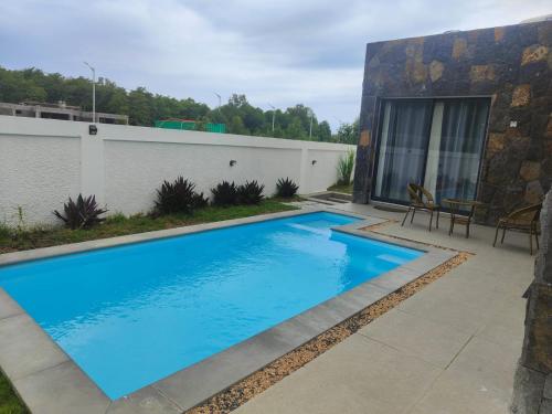a swimming pool with blue water in a yard at Villa Lune D'Eau in Poste Lafayette