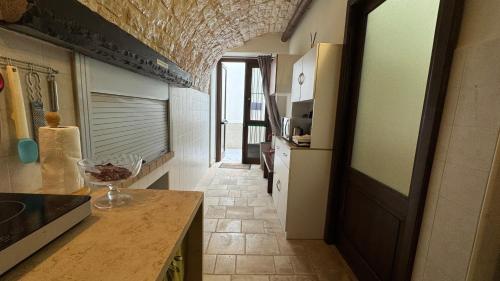 a kitchen with a counter and a hallway with a counter top at Vitti Stone House - 6 minuti dalle Grotte in Castellana Grotte