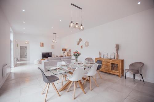 une salle à manger et un salon avec une table et des chaises dans l'établissement La Hacienda - Grande maison avec jardin, à Cambrai