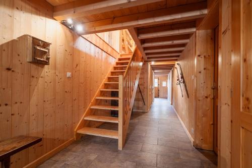 scala in legno in una camera con pareti in legno di Aux Sources - 14 personnes - sauna & jacuzzi a La Bresse