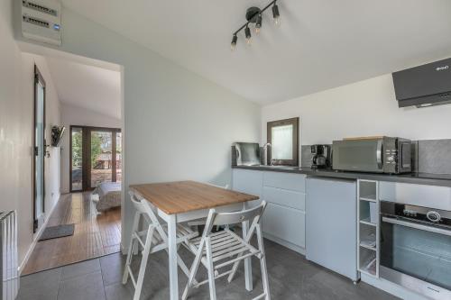 une cuisine avec une table en bois et des appareils électroménagers dans l'établissement Les clés du bassin, à Lège-Cap-Ferret