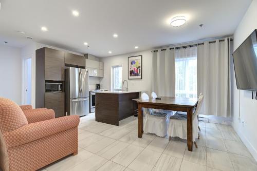 a living room with a table and a kitchen at Le Bijou Airhome in Montréal