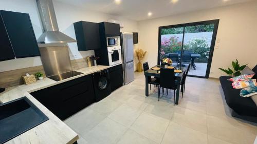 une cuisine et un salon avec une table et un canapé dans l'établissement Instant Janin - Logement T3 climatisé plain pied avec jardin, à Agde