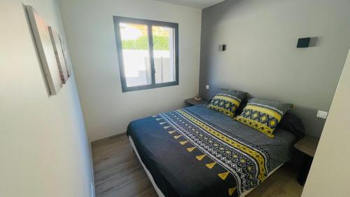 une chambre avec un lit avec des oreillers et une fenêtre dans l'établissement Instant Janin - Logement T3 climatisé plain pied avec jardin, à Agde