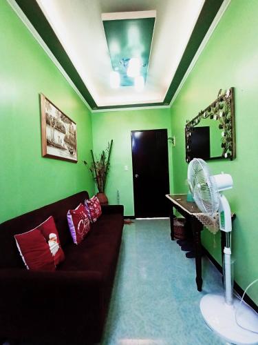 a living room with a couch and a fan at 2 - Cabanatuan City’s Best Bed and Breakfast Place in Cabanatuan