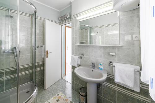 a bathroom with a sink and a shower at Radovčić Apartments and Rooms in Trsteno