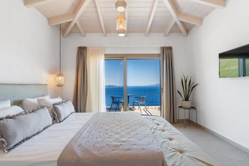 a bedroom with a large bed with a view of the ocean at Calliste Villa in Évyiros