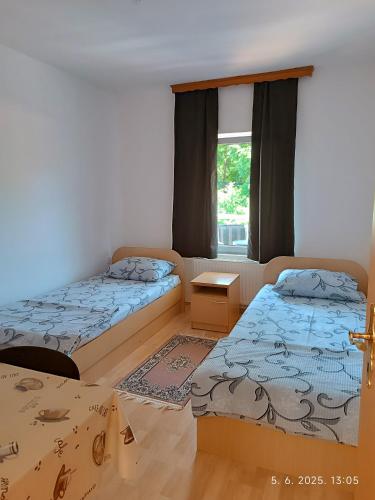 a bedroom with two beds and a window at Apartman ASI in Mostar