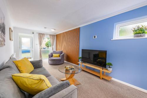 a living room with a gray couch and a television at Summer Deal 20 PRC OFF 4BR 2BATH Families Groups By Trinity Stays Short Lets & Serviced Accommodation Cambridge in Cambridge