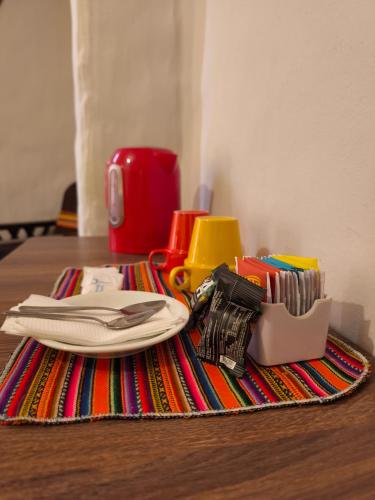 a table with a plate and utensils on a rug at Waalay Hotel in Huancayo